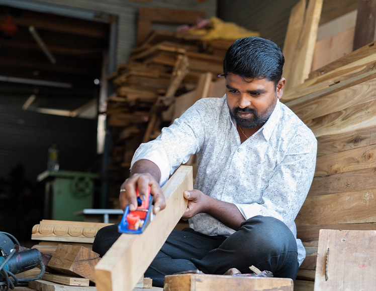 Carpenter working with timber at his workshop, an MSME borrower segment